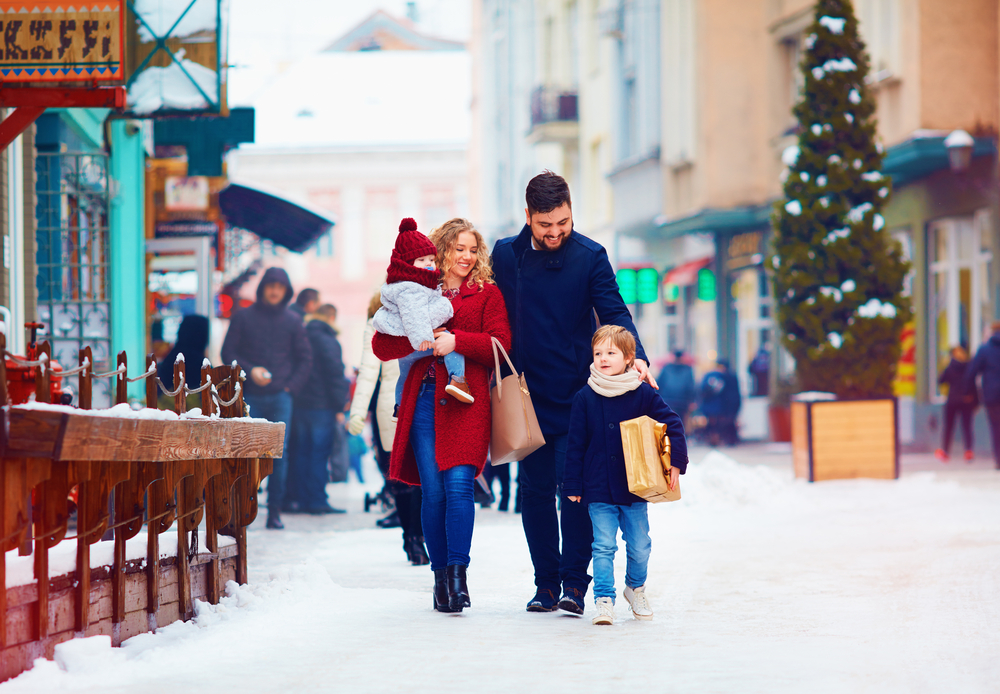 Happy,Family,Walking,Together,At,Snowy,City,Street,During,Winter